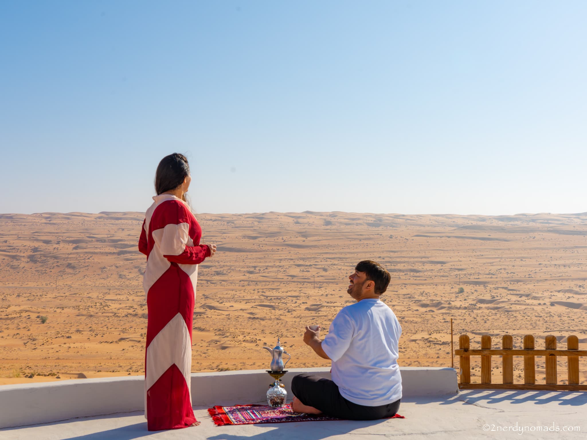 Urvi and Animesh enjoying traditional Omani coffee overlooking the sand dunes of Wahiba Sands, Oman.